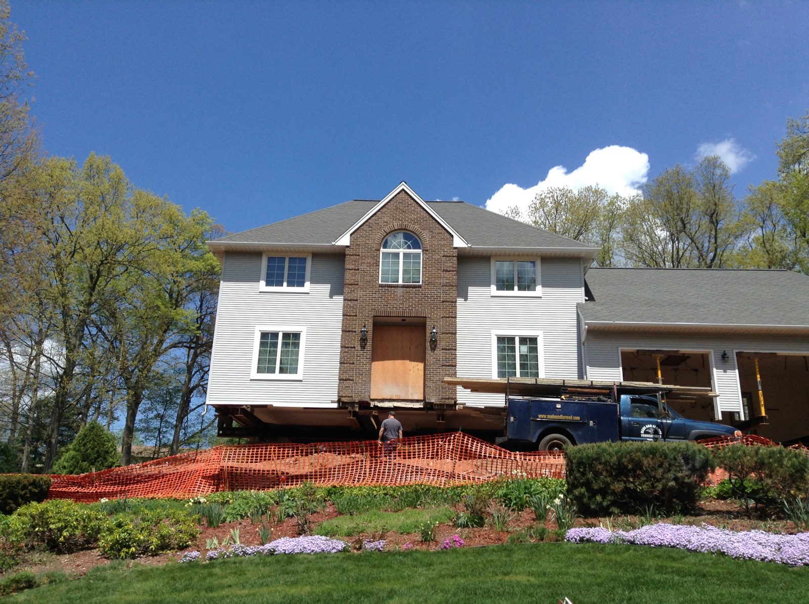 a home lifted up with workers replacing the foundation