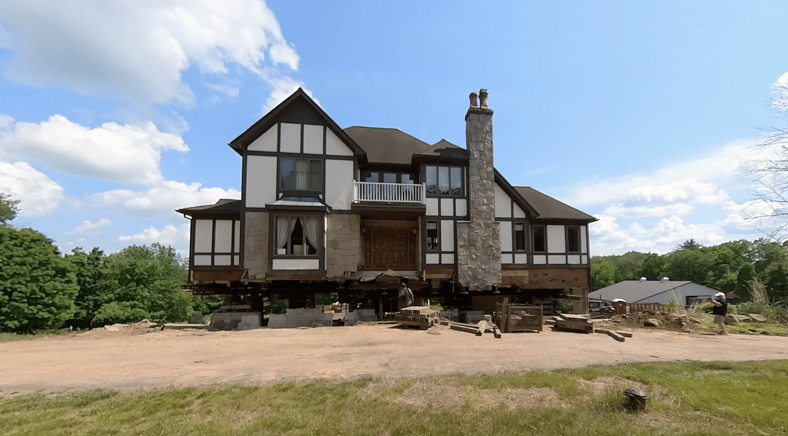 lifted house during foundation replacement. blue sky in the background. belchertown, ma